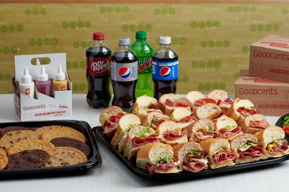 Trays of cookies and subs with soda behind