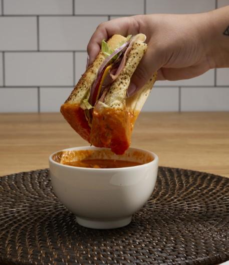 Dipping a sandwich in tomato soup